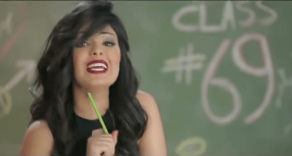  The singer appears in a mock classroom in front of a blackboard with 'Class #69' scrawled on it in chalk