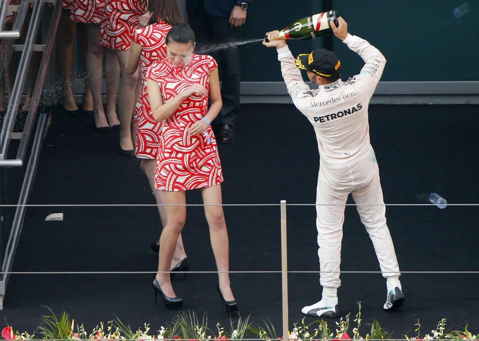  Lewis Hamilton sprays champagne at a podium girl in China in 2015