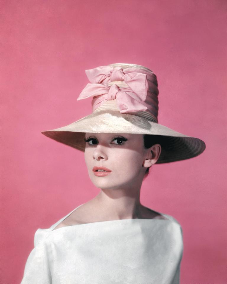  1957: Posing for a publicity still for Funny Face, Audrey hides her pixie haircut with a double bowed hat