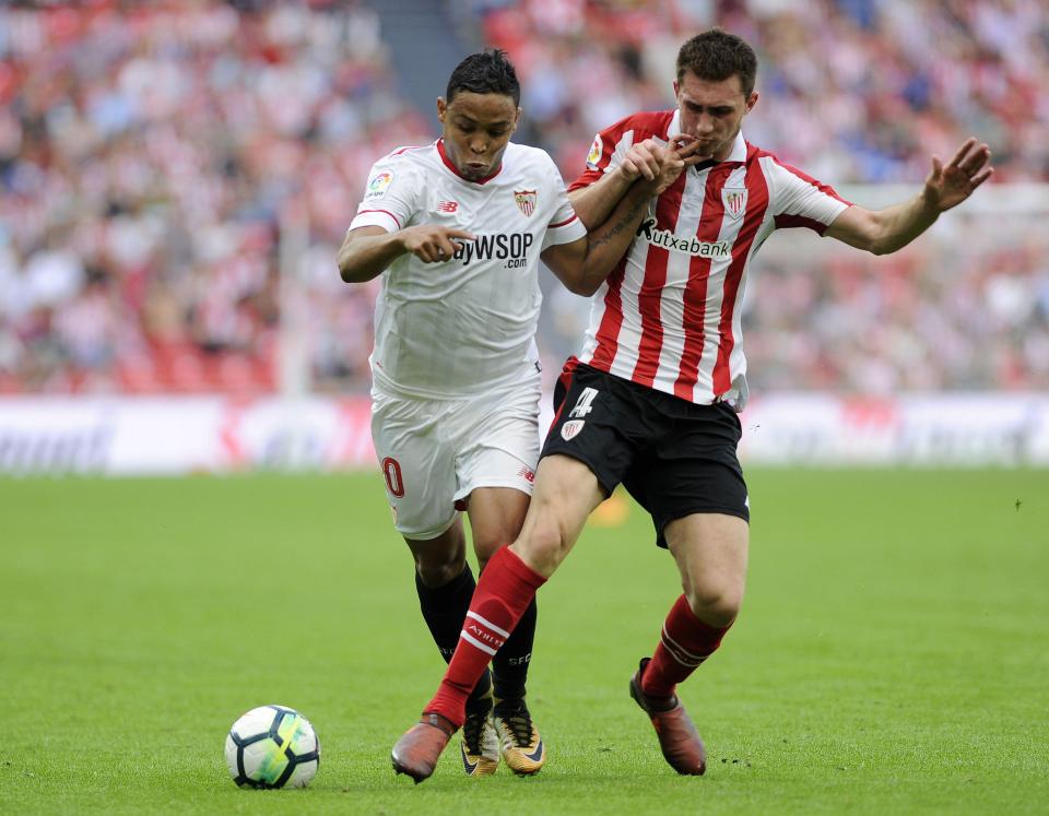 Aymeric Laporte puts in a strong challenge on Sevilla forward Luis Muriel