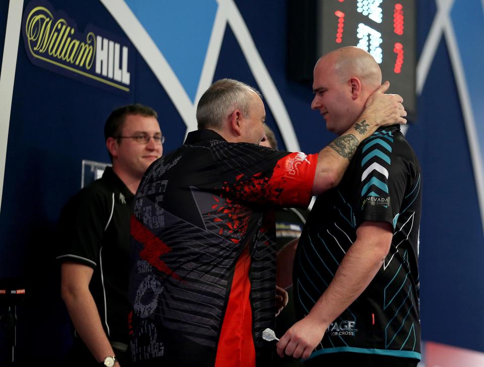  Phil Taylor embraces Rob Cross after his defeat