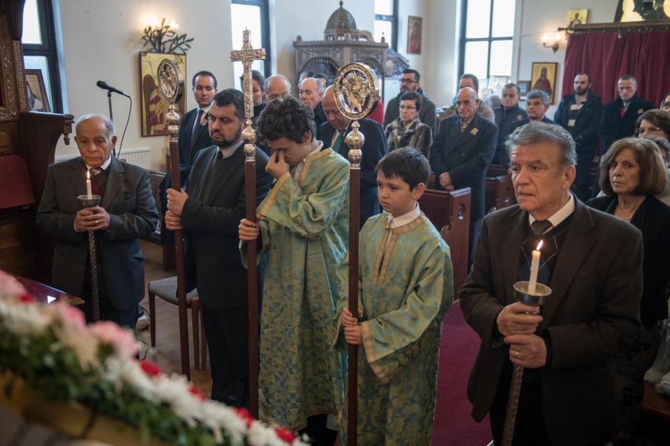  A young boy rubs his eyes during a traditional Greek Orthodox service at the Church of St Michael the Archangel for the Feast of the Epiphany