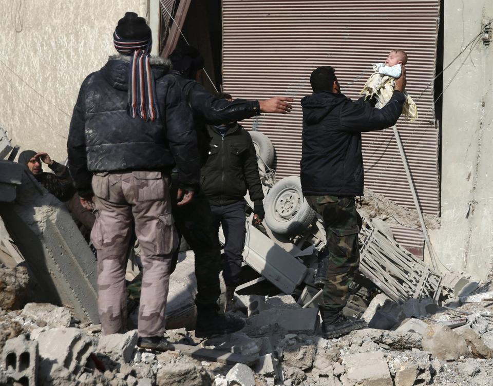  Syria has been crippled by nearly eight years of brutal conflict. Pictured, a man holds a wounded child as he stands on debris of damaged buildings