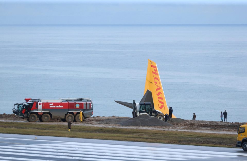 Emergency workers survey the scene surround the plane