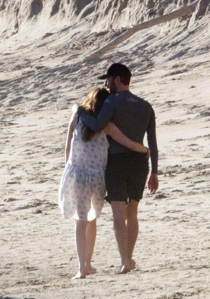  Chris Martin and Dakota Johnson wrapped their arms around each other as they went for a stroll on the beach in Malibu