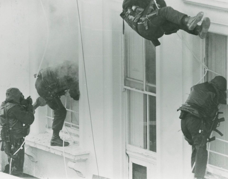  SAS fighters are pictured smashing through the windows of the Iranian embassy in London during their iconic raid in 1980