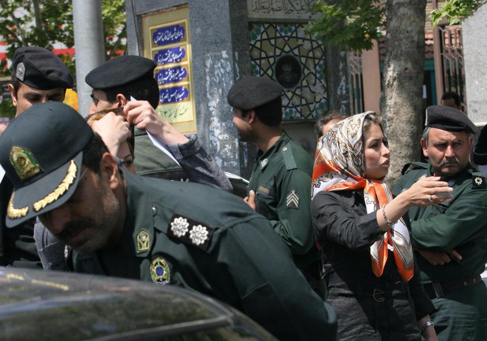  Iranian policemen warn women about their clothing and hair during a crackdown to enforce Islamic dress code in Tehran