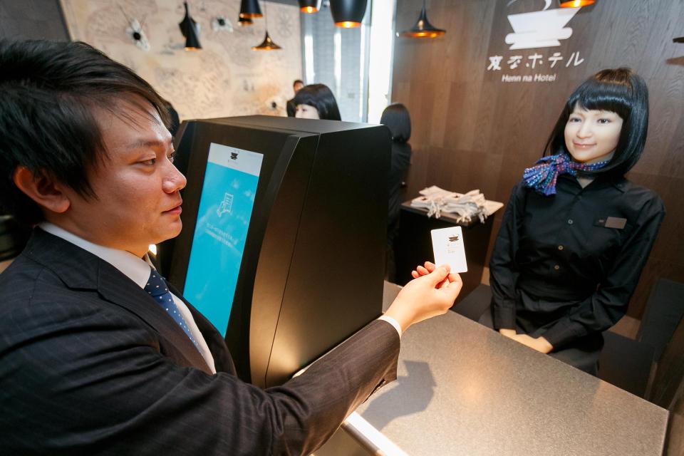  One customer is pictured handing over a card to the friendly humanoid staffer