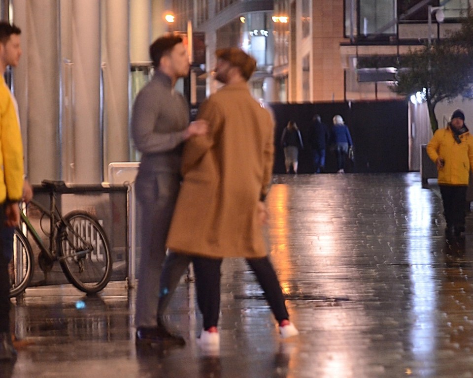 Security guards watched on as the pair spoke on the street in Manchester