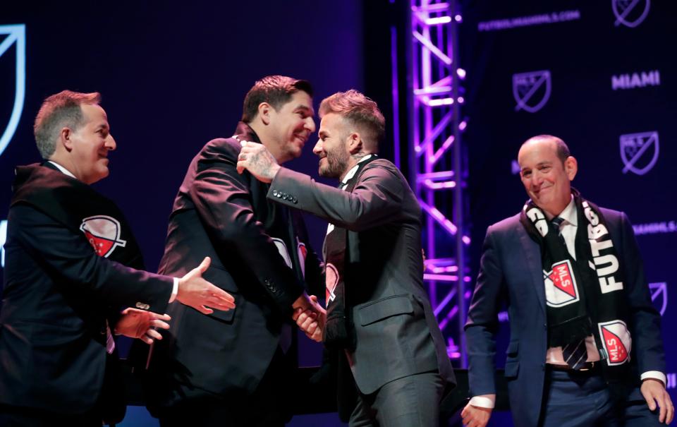  Beckham hugs fellow joint-owner Marcelo Claure