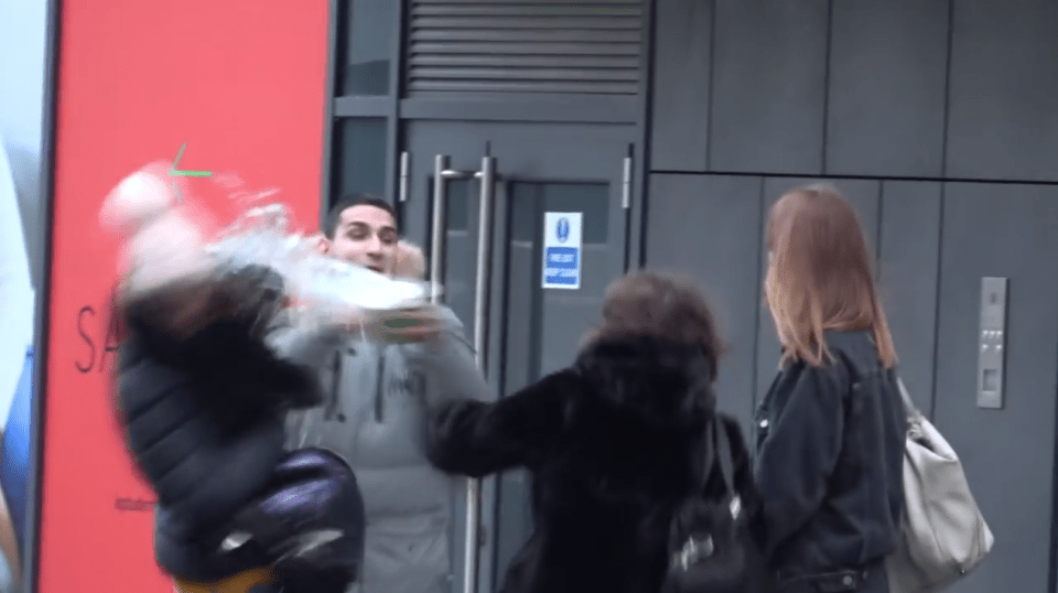  In the video he appears to hurl water at members of the public