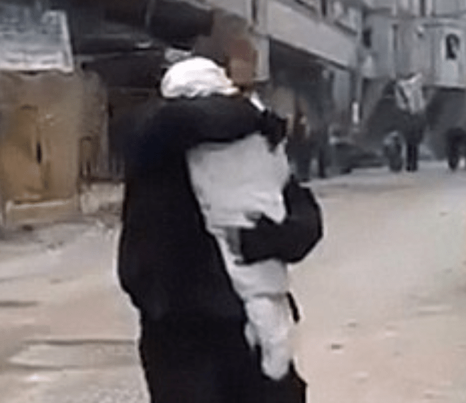  A distressed Syrian dad cradles the body of his dead child after the bloodiest air strike in years