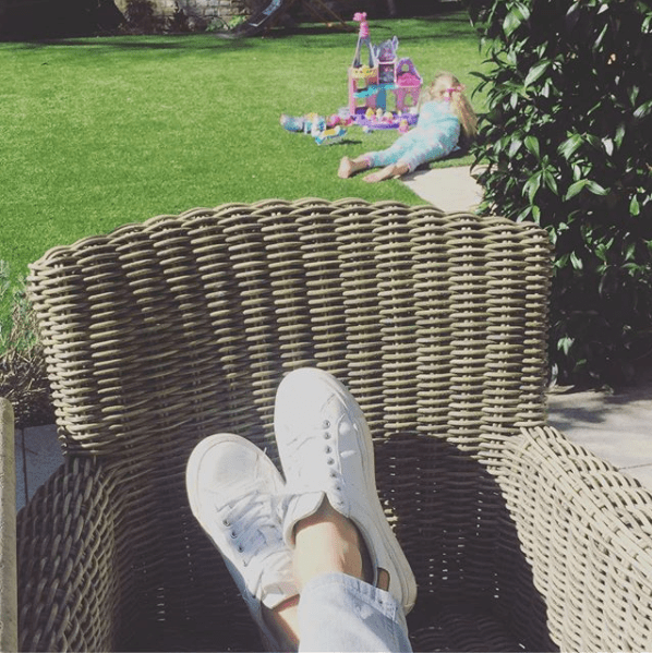  Holly puts her feet up in one pic showing a wicker garden chair and grassy lawn complete with childrens' slide