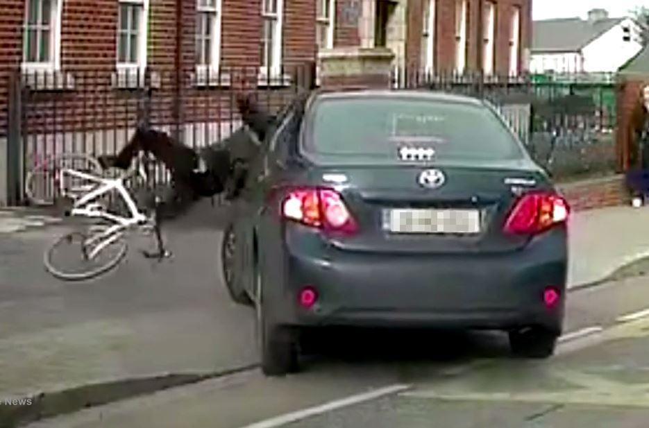 The cyclist collides with the car which was turning into the police station