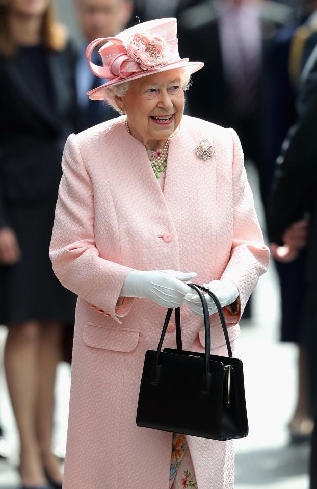  The Queen clutches her black Launer handbag - which avoids any awkwardness from people who may want to shake their hands