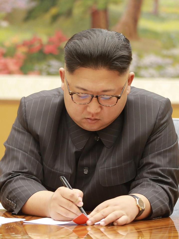  Experts claim this photo shows Kim 'signing off' on plans to put rockets on standby, should he want to strike the US