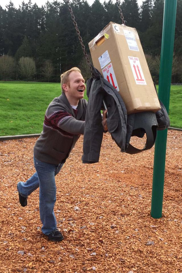  The couple had fun putting the cardboard box on the swings in the park