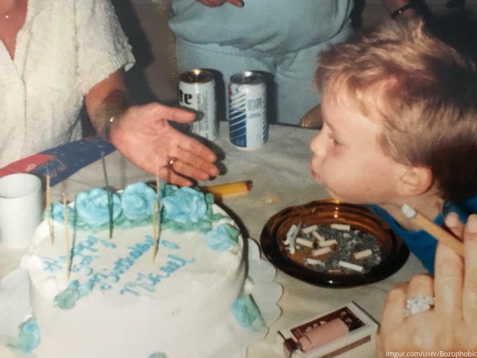  The child is pictured blowing out his birthday candles surrounded by beer, cigarettes, and an ashtray.