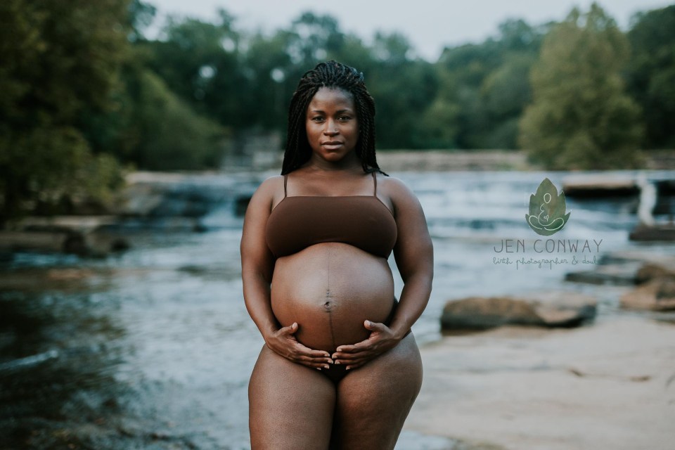 A heavily pregnant woman poses for the camera 