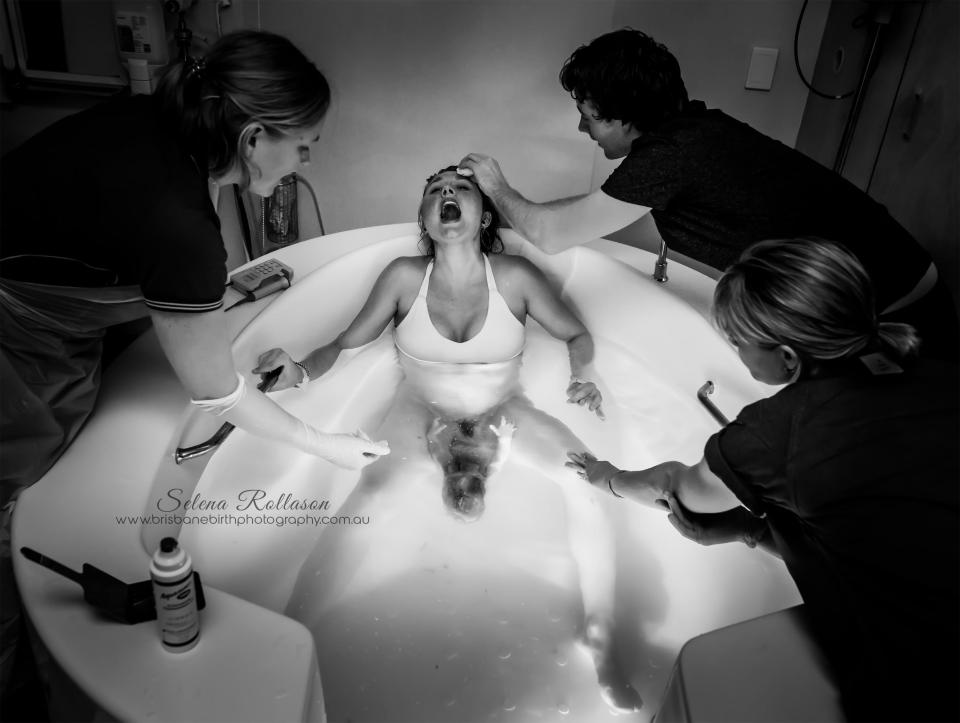 A woman screams in agony as she gives birth to a baby in a pool 