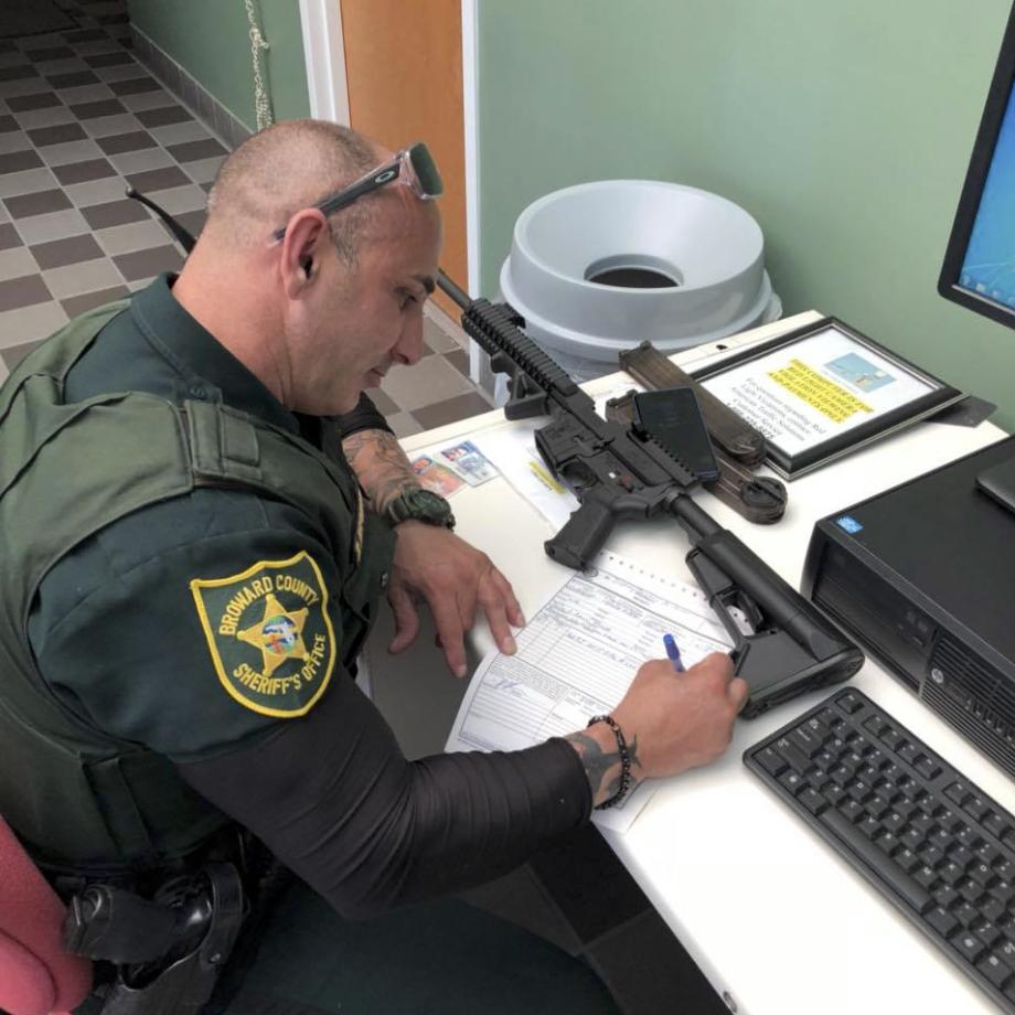  Gun owner Ben Dickmann surrendered his AR-style firearm two days adter the Parkland, Fla. school mass shooting that left 17 students and adults killed to a Broward County, Florida, Sheriff's Deputy - pictured here - to destroy