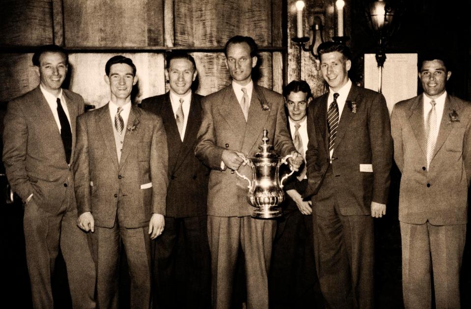  Blackpool captain Harry Johnston holds the FA Cup alongside his teammates in 1953