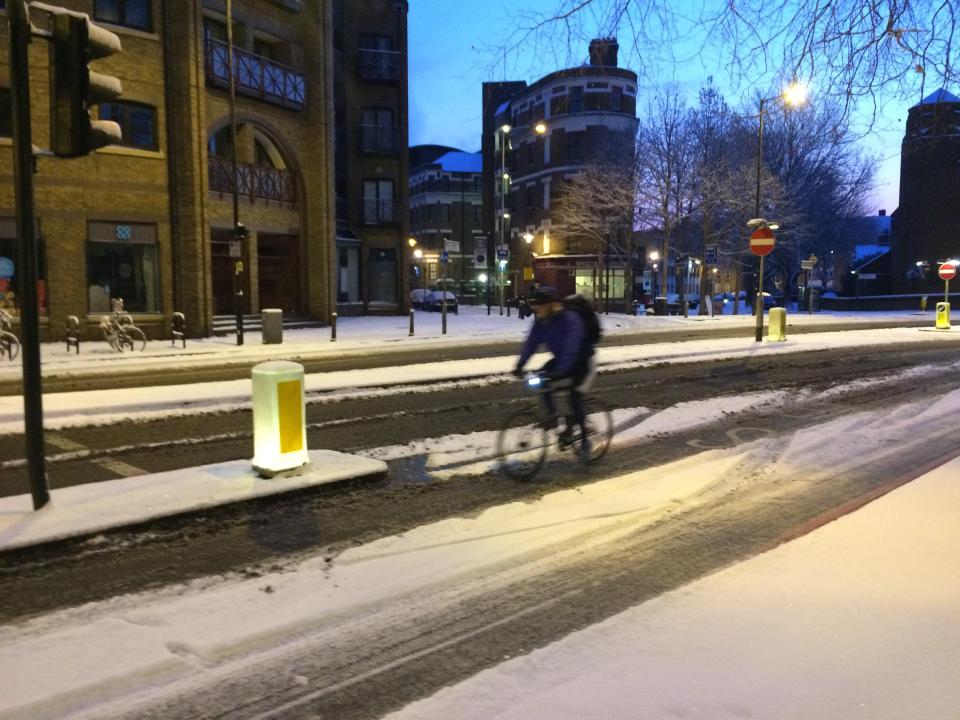 A cyclist made his way gingerly through a snowy London this morning