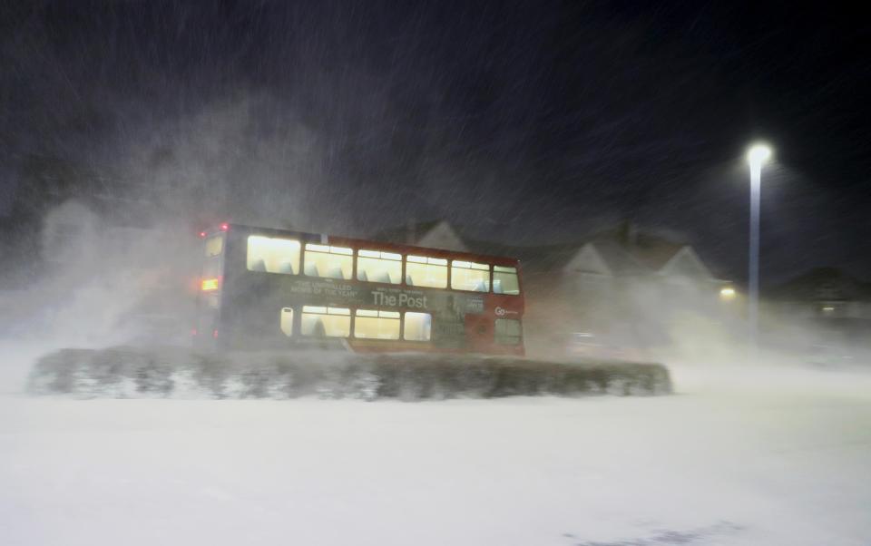  A bus drives through a snow storm in Whitley Bay this morning