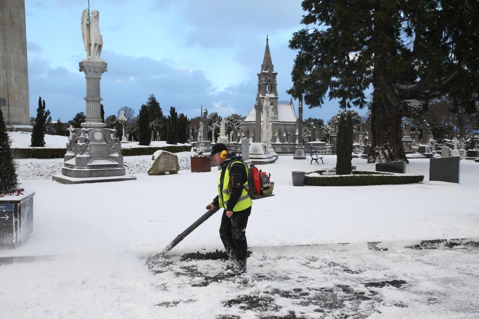  Groundsman Luke Gray clears a snow-covered road at Glasnevin cemetery in Dublin