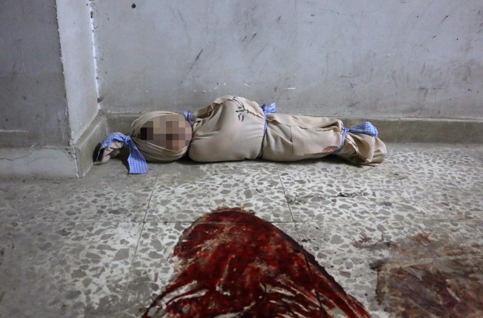  The body of a Syrian baby lies wrapped in a shroud on the floor of a makeshift clinic