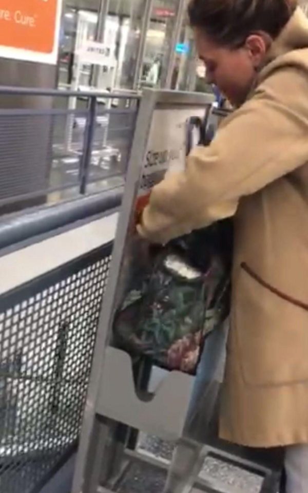 Natalia Rutkowski demonstrates that she can fit her cabin bag into the box that shows size requirements for United Airlines hand luggage