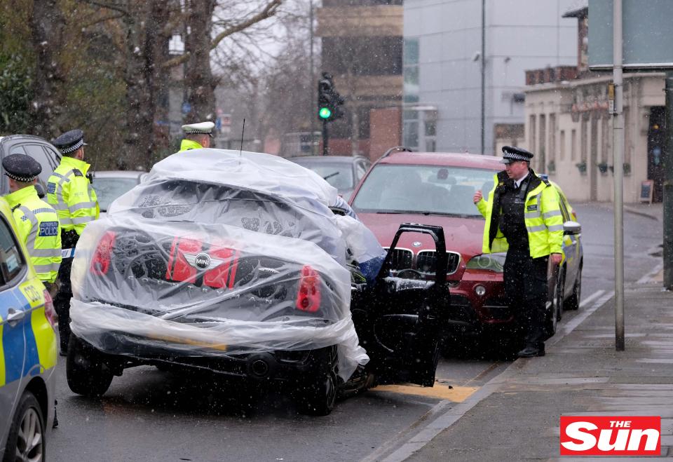  Police officers surround the TV personality's car following the crash