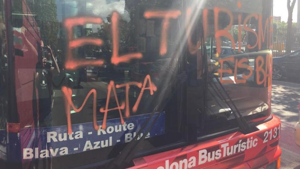  Graffiti on a bus sprayed by an anti-tourists group reads: "Tourism kills neighbourhoods"