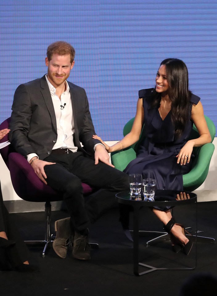 Meghan rests a protective hand on Harry’s arm