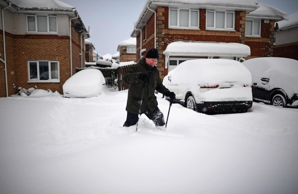  A man wades through the deep snow in Alexandria, Scotland, this morning