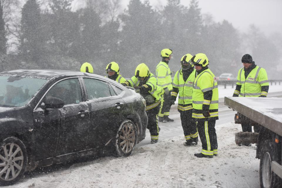  Rescuers attempt to push a car in Cornwall which is stuck on the ice