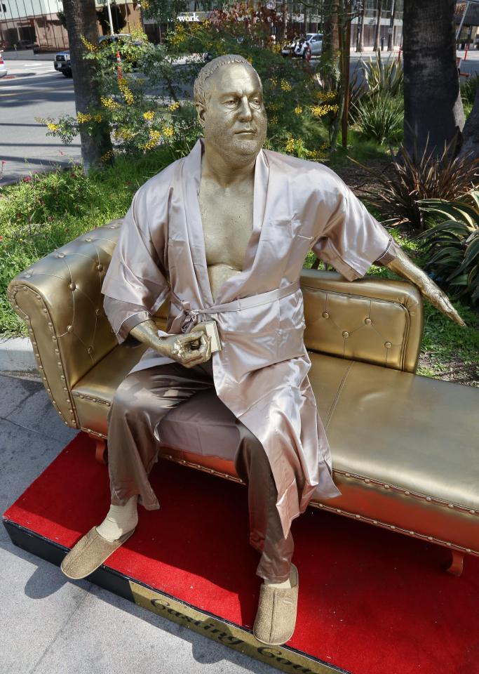  The statue depicts the shamed movie mogul in gold wearing a bathrobe and holding an Oscar