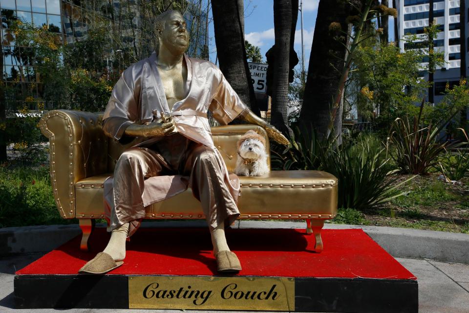  A dog named "Sassi" sits next to a golden statue of a bathrobe-clad Harvey Weinstein, seated atop a couch on the sidewalk along Hollywood Boulevard, just feet from where the stars will gather for this Sunday's Oscars ceremony