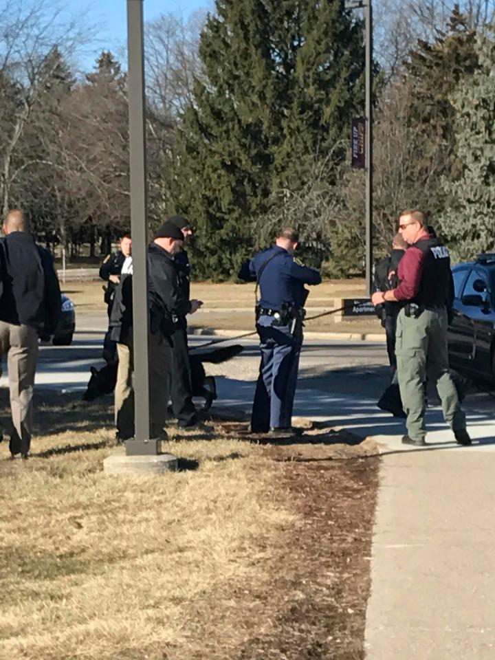  Authorities gather on the campus of Central Michigan University during a search for the suspect