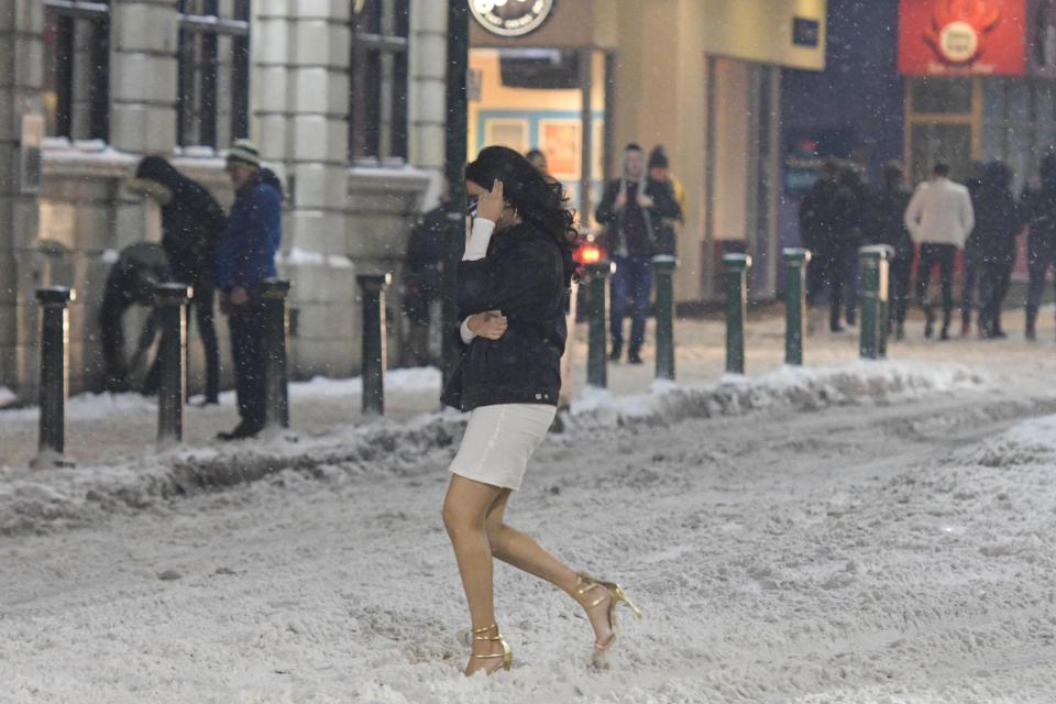 A Birmingham woman in a skirt and high heels walks through the intense conditions