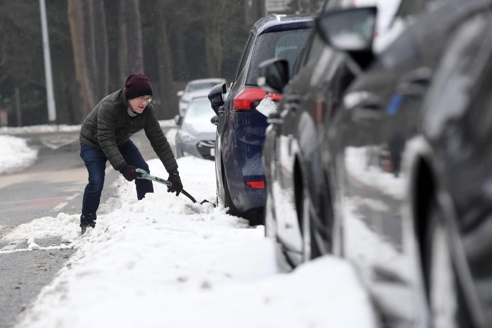  A man digs his car out of the snow as the cold weather continues to hit Cardiff