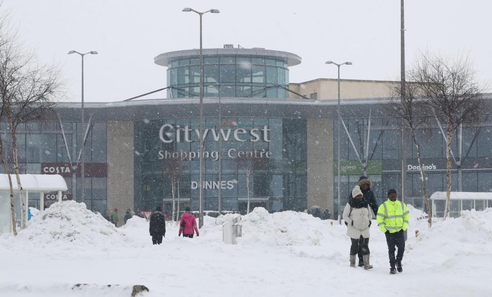  People make they way from the City West shopping centre in Dublinas a status orange weather alert remains in many counties in Ireland