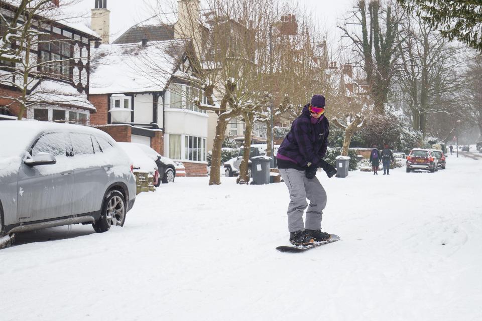  A man snowboards down Park Hill, in Birmingham as snow and sub-zero conditions have blighted Britain's roads, railways and airports