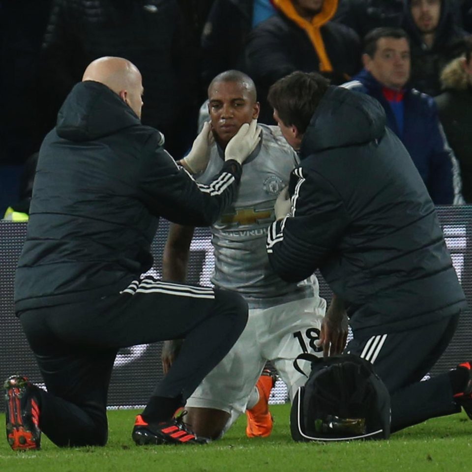 Ashley Young receives treatment after a nasty clash of heads in the first half