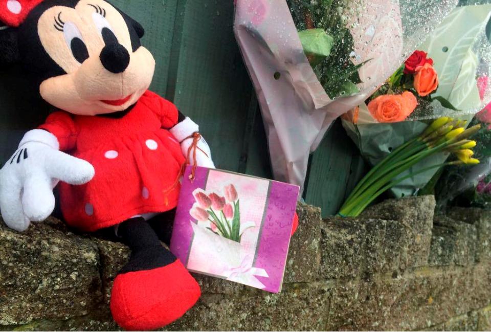  A Minnie Mouse teddy bear lies with a card and flowers at the scene where Maisie was hit by the car