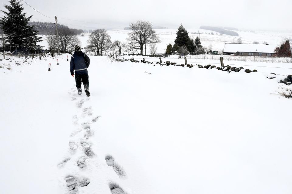  A resident leaving tracks in the snow in rural Carron Valley near Stirling, Scotland