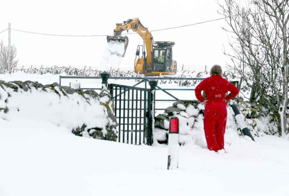  Hilary Morton watches over a digger clearing deep snow in rural Carron Valley near Stirling, Scotland