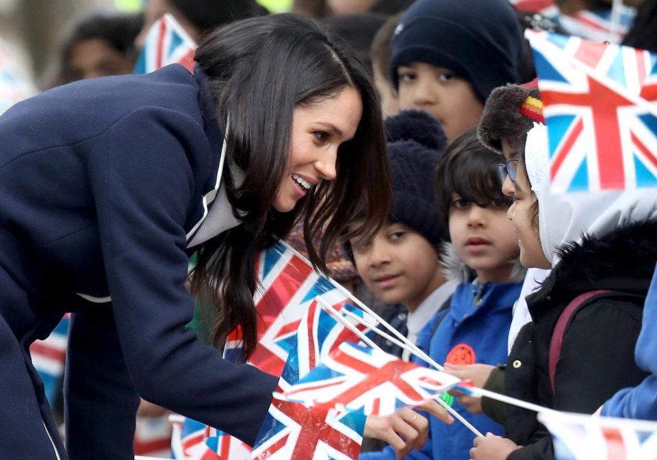  Meghan crouches to greet children in Birmingham