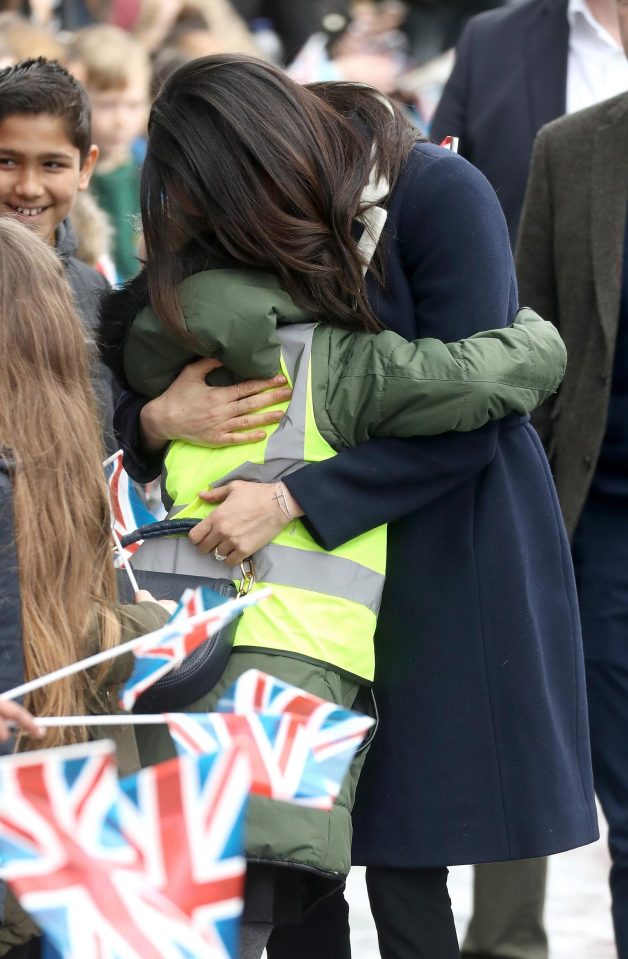  Meghan hugs a child from the crowd during the walkabout in Birmingham