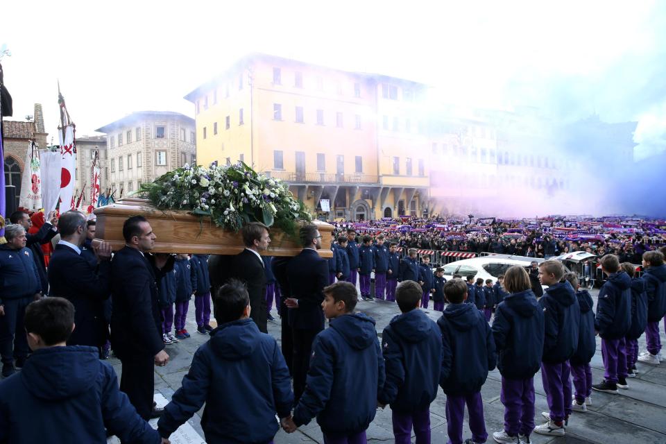 The coffin leaves Basilica di Santa Croce as Fiorentina fans let off violet flares and hold their club colours high in tribute to their captain